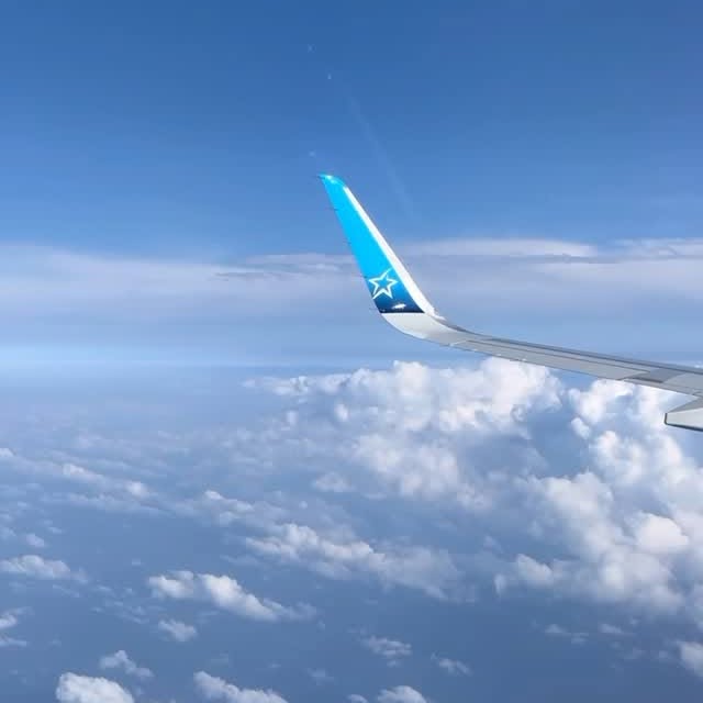 Instagram post by @flyavecnico for Air Transat. Caption reads: Views that takes you places. Every window is a new....