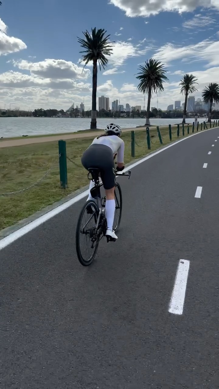 Instagram post by @ash_l_gardner for 2XU. Caption reads: The only way to build for a half Ironman is one....