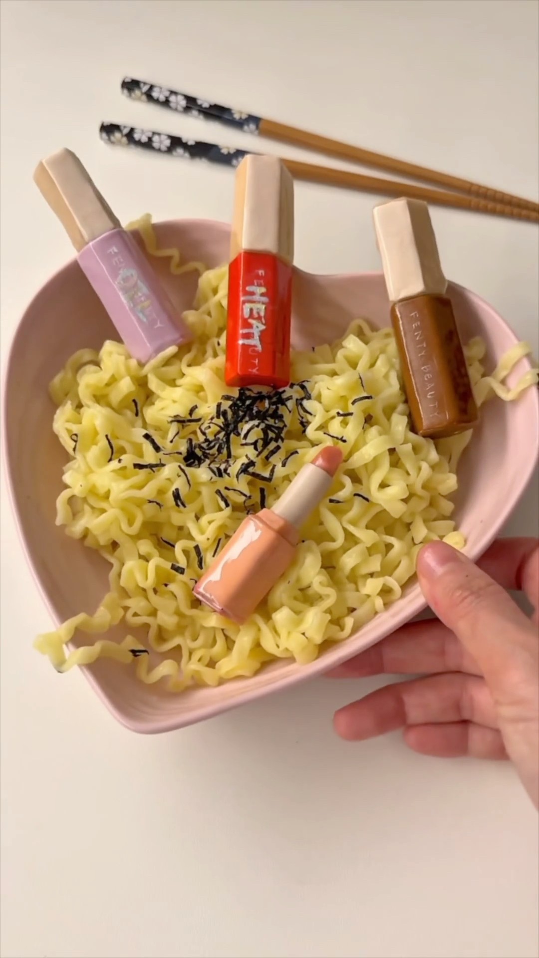 Instagram post by @sibatable for FENTY BEAUTY BY RIHANNA. Caption reads: What we mean when we say we cooked with Gloss Bomb....