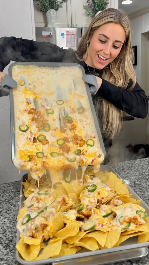 Instagram post by @girlgonegrilling for Kinder's. Caption reads: Sliding sheet pan nachos with buttery buffalo....