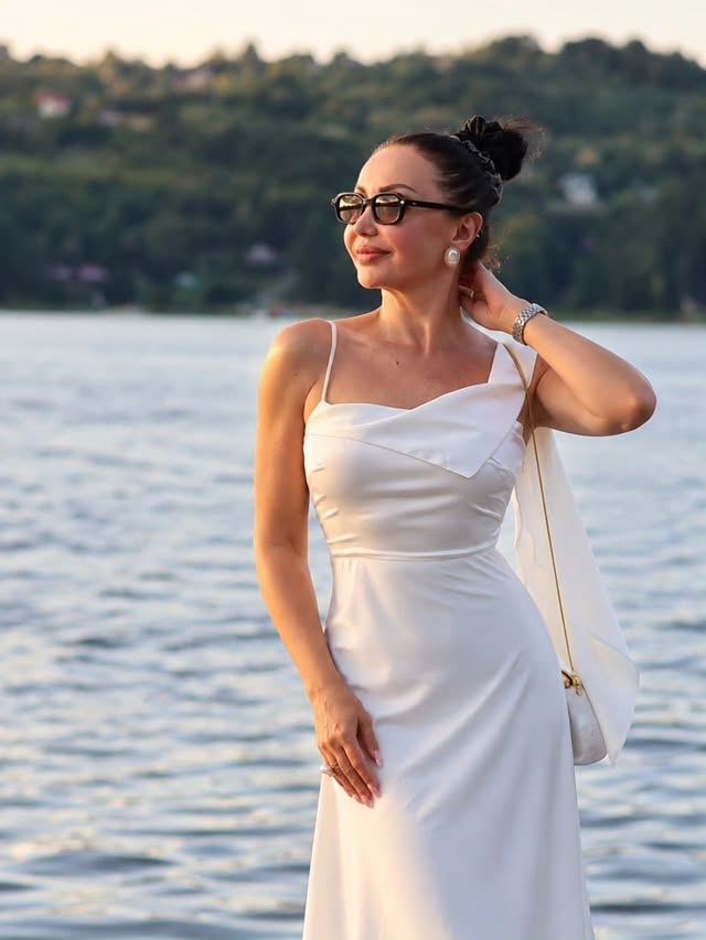 Instagram post by @travelgirl_she for Rihoas. Caption reads: [...] hour, white satin & summer elegance....