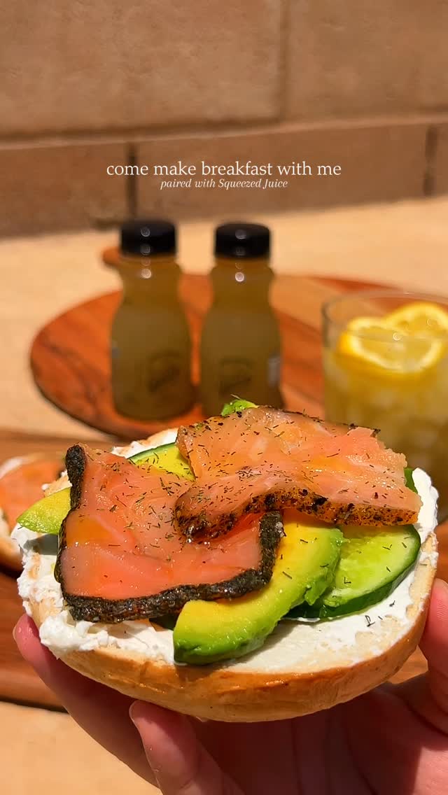 Instagram post by @nourishedbynour_ for The Squeezed Juice. Caption reads: SMOKED SALMON BAGEL with @thesqueezedjuice 🥯🥑🍋....