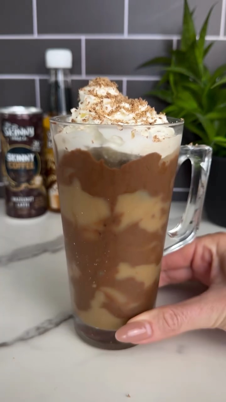 Instagram post by @slimming.gym.and.gin for The Skinny Food Co. Caption reads: Catch me vibin’ with my iced hazelnut latte all....