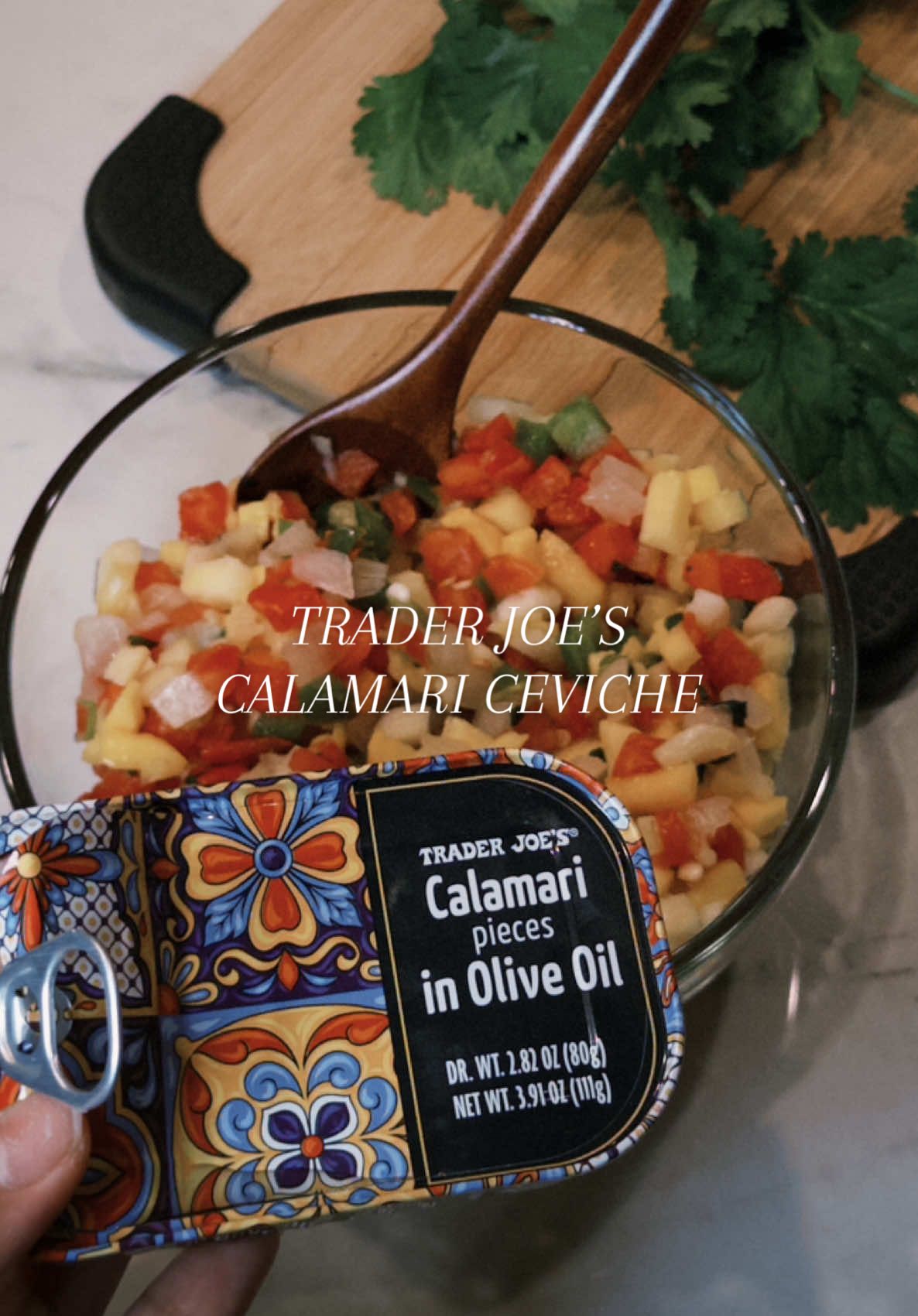 TikTok post by @katerynnnn for Trader Joe's. Caption reads: this tinned calamari and mango pineapple pico de....