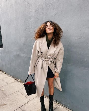 Instagram post by @annashafffer for 12 STOREEZ. Caption reads: [...] READY FOR YA in my 🤩 new coat 🤩 from....