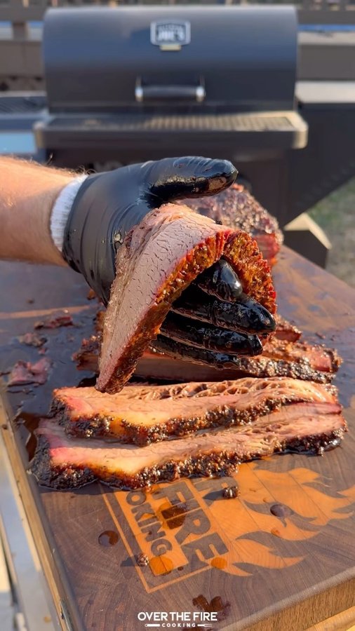 Instagram post by @overthefirecooking for Oklahoma Joe's. Caption reads: Overnight Smoked Brisket with @oklahomajoes #ad....