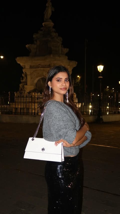 Instagram post by @shubhra.vaity for AJIO. Caption reads: [...] ✨

#ToryBurchHoliday25 #ToryBurch #AjioLuxe....