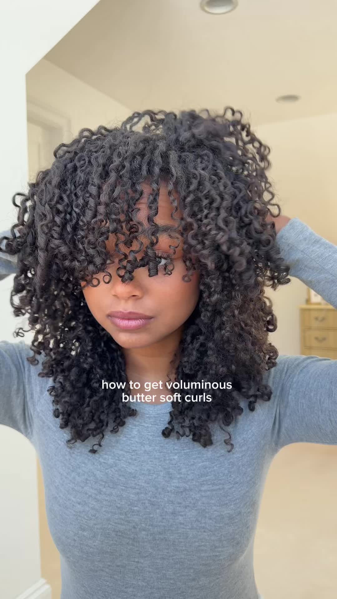 TikTok post by @rreaquel for Amika. Caption reads: [...] curls without sacrificing volume with @amika....