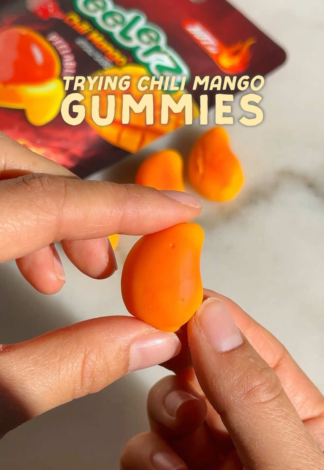 TikTok post by @eatsbyrachel for Amos Sweets. Caption reads: [...] CHILI MANGO PEELABLE GUMMIES 🔥💥🥭 @Amos....