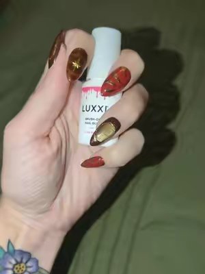 TikTok post by @paigers007 for Luxxi Nails. Caption reads: [...] to use my fav brush on nail glue by @LUXXI....