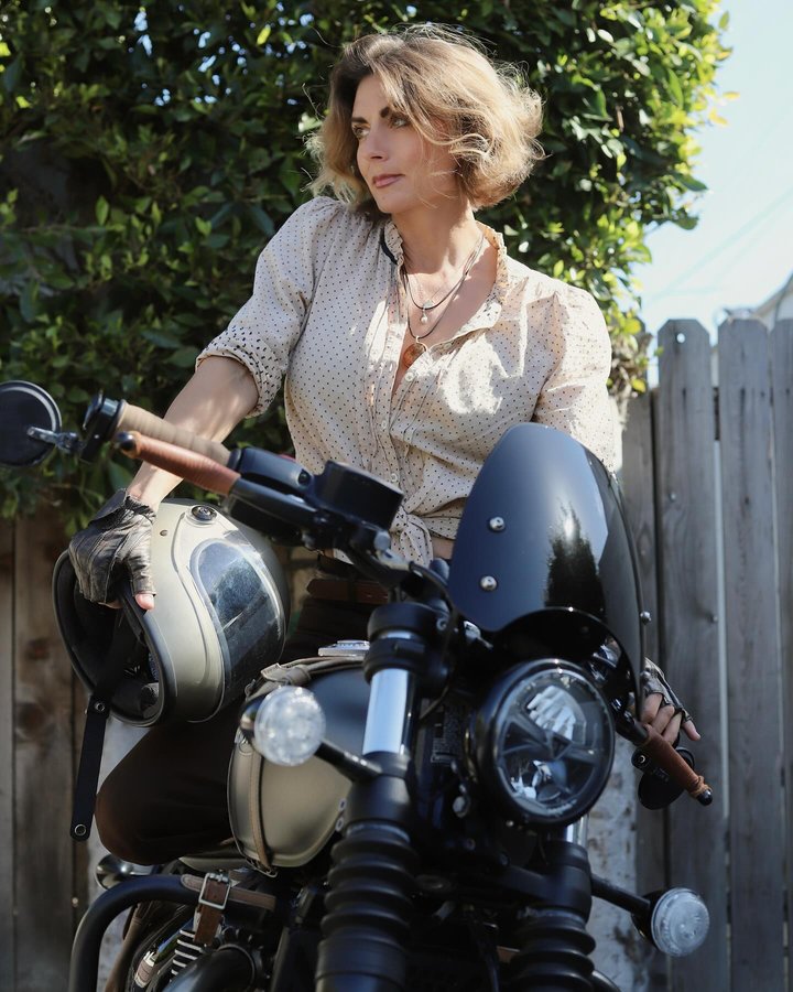 Instagram post by @triumphmotorcyclegirl for Biltwell. Caption reads: I {paired} the retro Levi Mens Action slacks with....