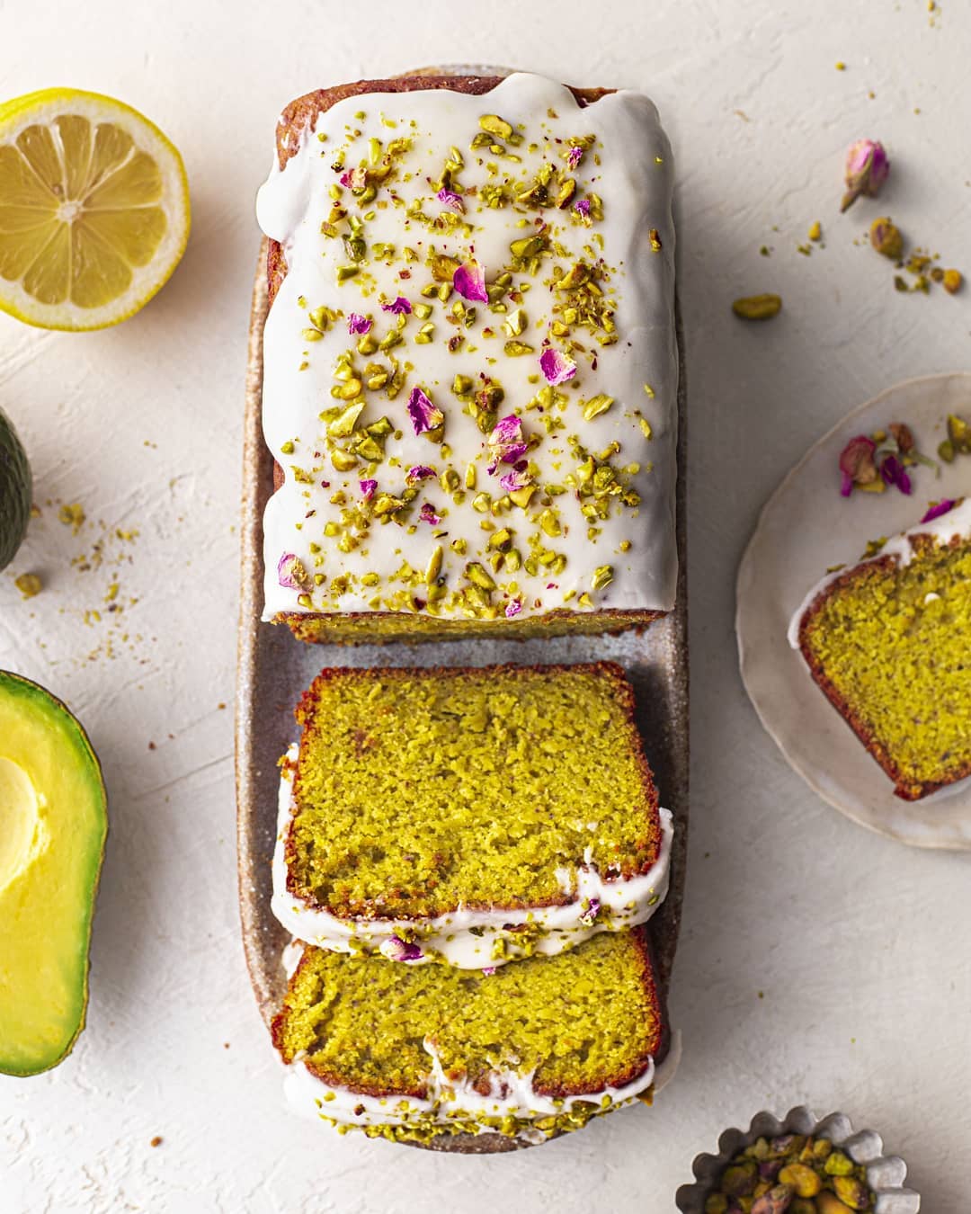 Instagram post by @rainbownourishments for THRIVE Magazine. Caption reads: Still craving this Avocado Pistachio Lemon cake –....