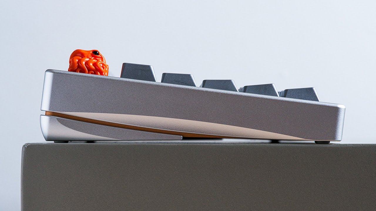 YouTube post by @alexotos for Unikeyboards. Caption reads: The Neo75 CU — Neo Did It Again....