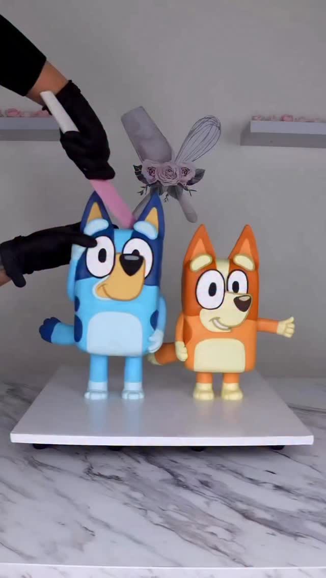 Instagram post by @graceys.cakes for Bluey. Caption reads: Bluey & Bingo Cake 💙🧡 Character cakes have a....