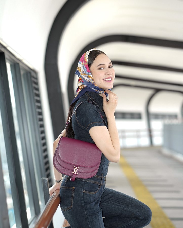 Instagram post by @yasminnapper for Etienne Aigner AG. Caption reads: On the go with my cherry red @aignermunich....