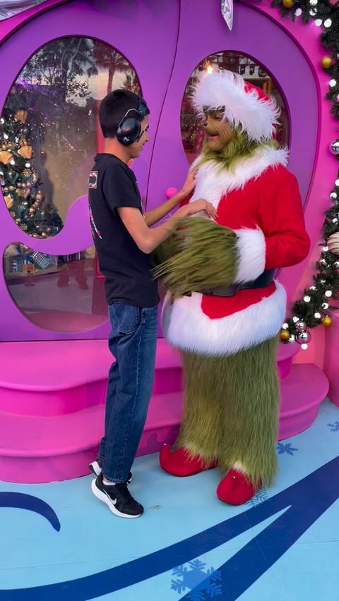 Instagram post by @magicwiththomas for Universal Studios Hollywood. Caption reads: The Grinch asking Thomas if he wants to touch his....