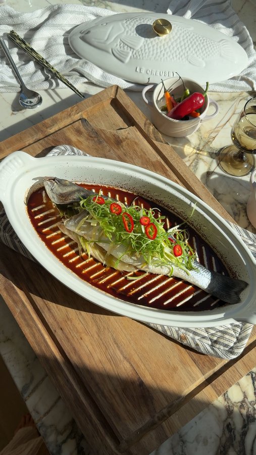 Instagram post by @emeraldcchan for Le Creuset. Caption reads: Cantonese steamed fish made with the @lecreuset....