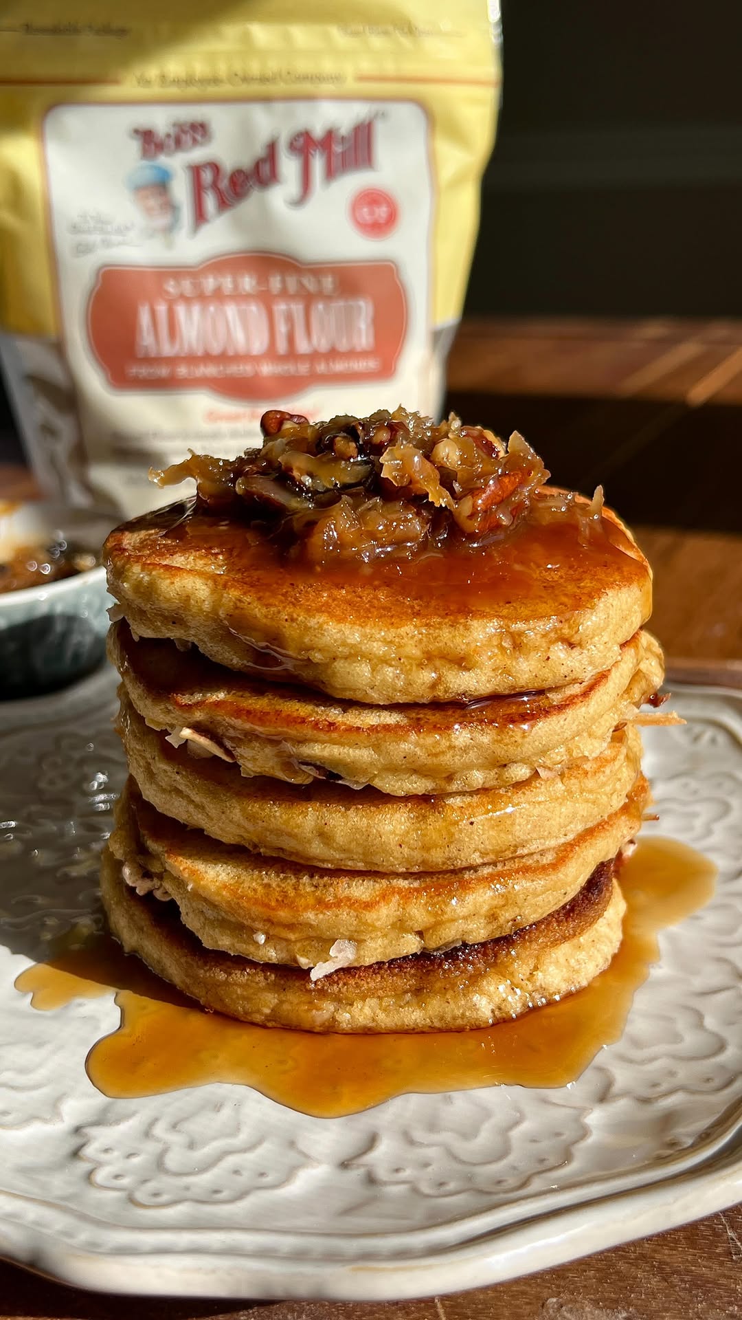 Instagram post by @wellmadebykiley for Bob's Red Mill. Caption reads: TOASTED COCONUT PECAN ALMOND FLOUR PANCAKES

#ad....
