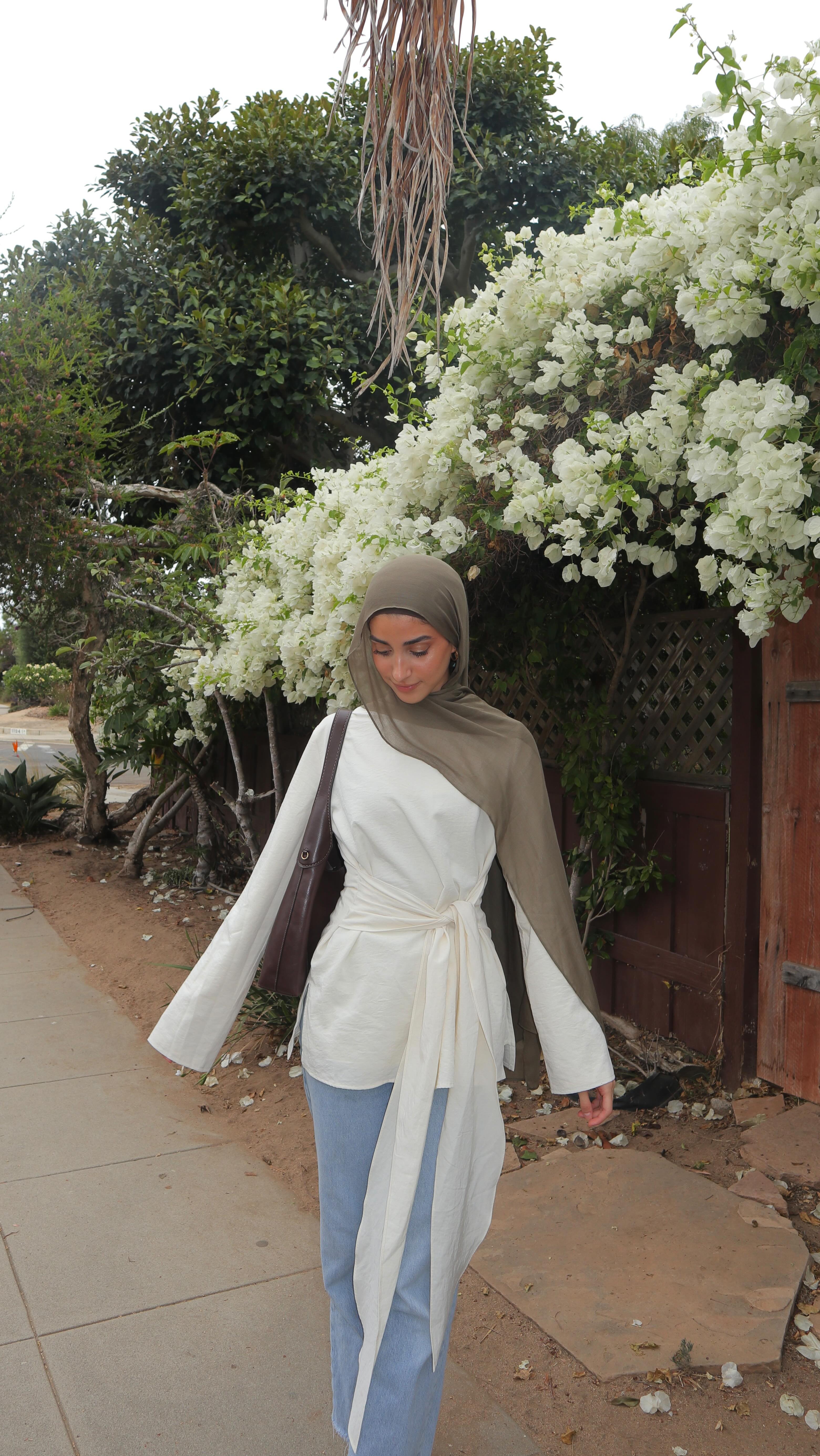 Instagram post by @norhanajaj for Veiled. Caption reads: Outfit of the day 🤍 wrap top from....