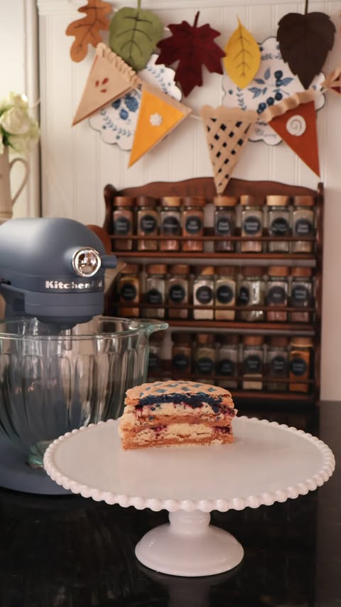 Instagram post by @emiliamariehome for KitchenAid. Caption reads: Blueberry pie macaron cake with @kitchenaidusa....