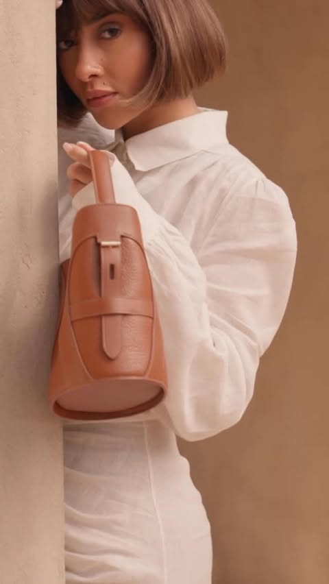 Instagram post by @balqeesfathi for Etienne Aigner AG. Caption reads: Confidence starts with what you carry. Sharing my....