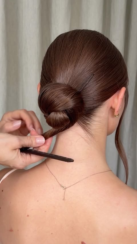 Instagram post by @kasia_fortuna for Moroccanoil. Caption reads: The secret to making a clean low bun look....