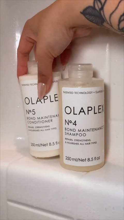 Instagram post by @wellnesswithmonette for OLAPLEX. Caption reads: [...] — and it all starts in the shower. ✨ Olaplex....