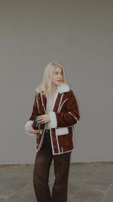 Instagram post by @olga_lavric for REVOLVE. Caption reads: @revolve ✨ coat on, lipstick ready, pretending....