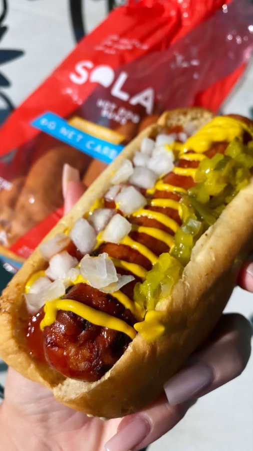 Instagram post by @chrissybuns for The Sola Company. Caption reads: HOT DOG TIME 🌭 spent the day with family cookin’....