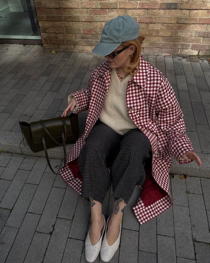 Instagram post by @lucyroseford for OMNES. Caption reads: Gingham and grids ❤️🖤 Trench and jumper @omnes *....