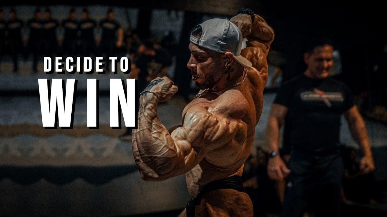 YouTube post by @MuscleBrawn for ENHANCED Labs. Caption reads: DECIDE TO WIN 🏆Gym Motivation.