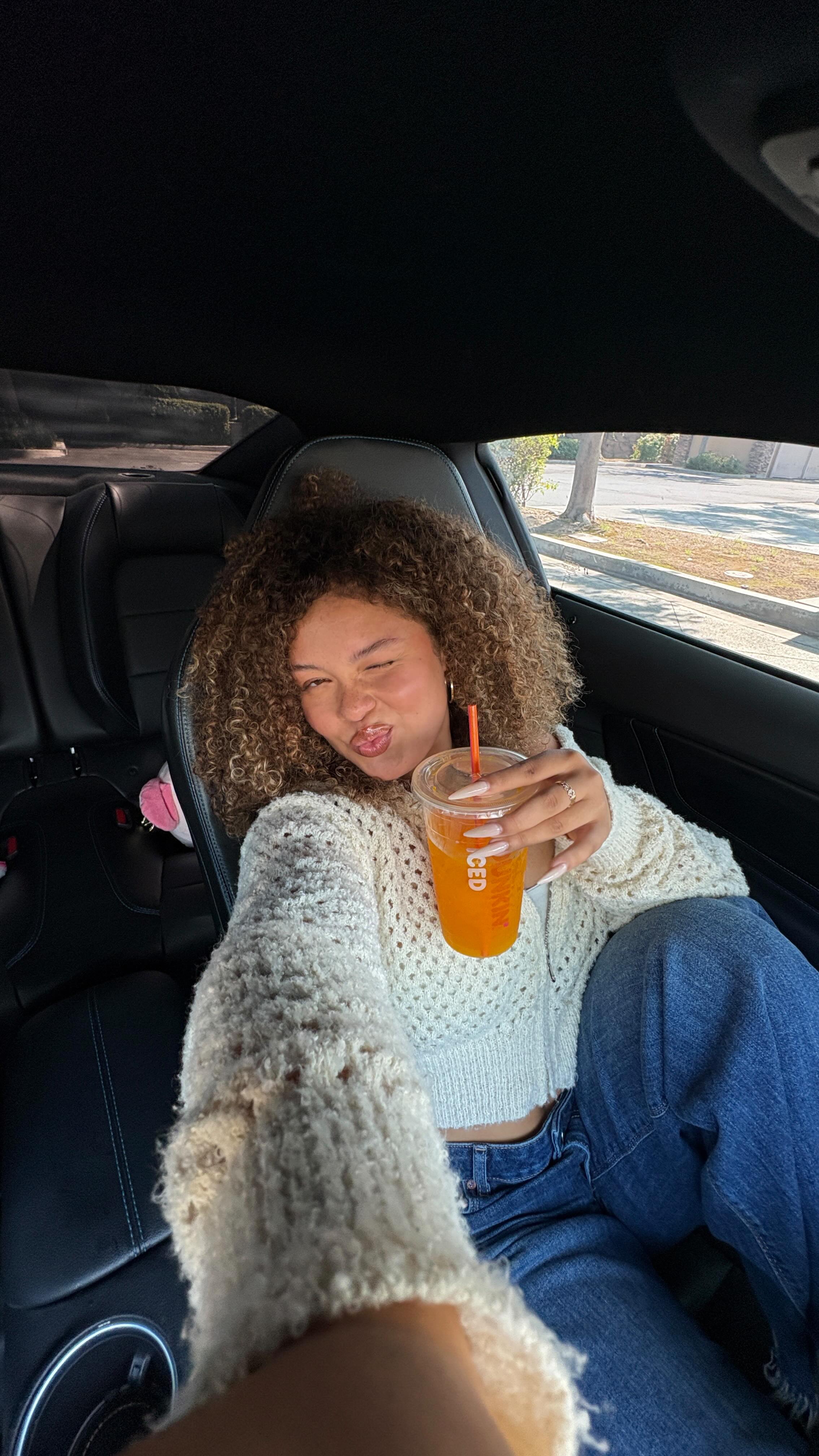 Instagram post by @tahaniariel for Dunkin’. Caption reads: Fall reset = cozy fit, my fave Dunkin’ Refreshers,....