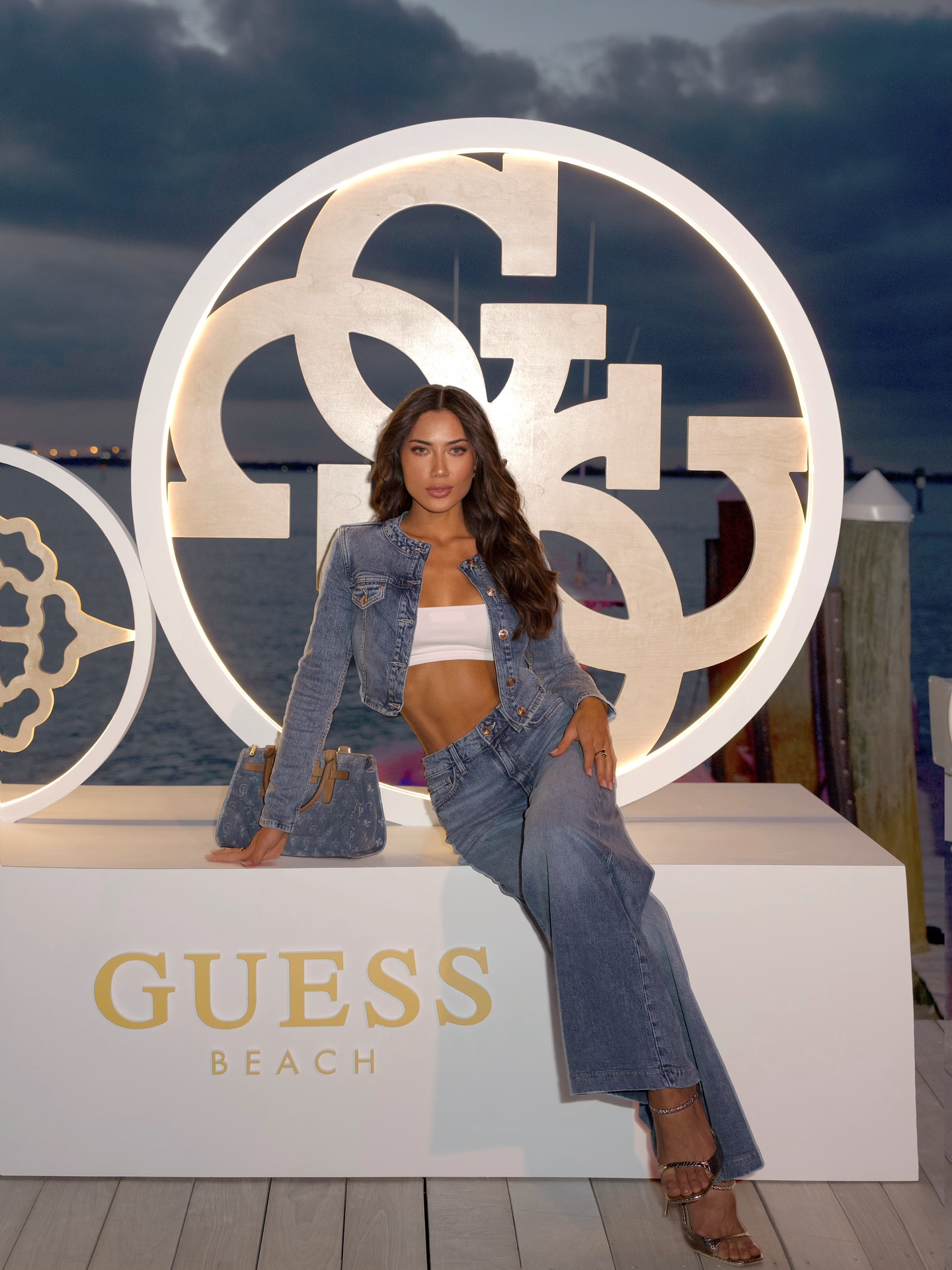 Instagram post by @georginamazzeo for GUESS. Caption reads: @guess Beach Club vibes hitting just right during....