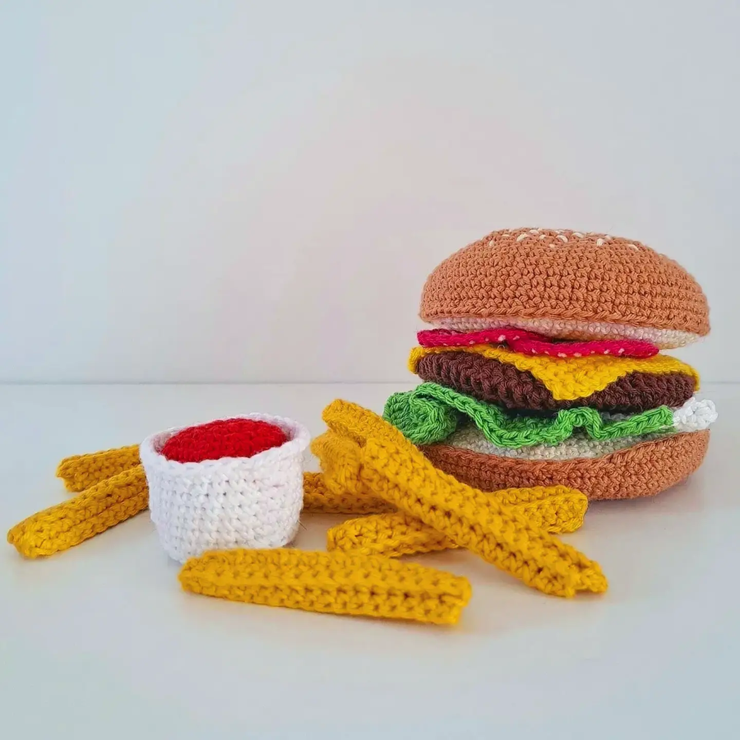 Instagram post by @virkase for Hobbii. Caption reads: It's BBQ time🍔🍟 Hamburger pattern @hobbii_yarn....