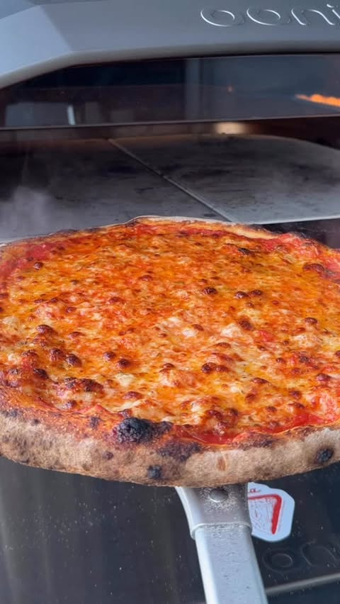 Instagram post by @7thfloorpizza for Ooni. Caption reads: [...] Here's my NY-Style pizza baked in the Ooni....