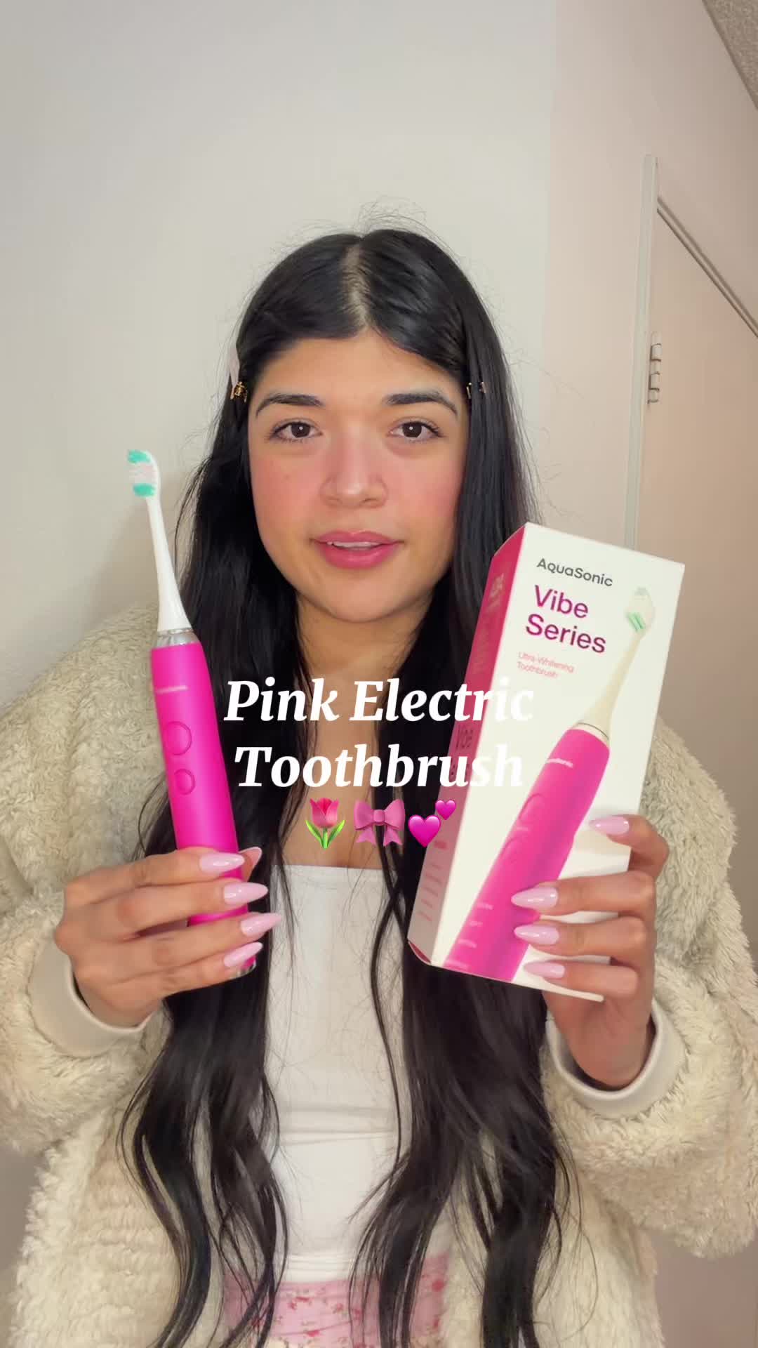 TikTok post by an influencer for AquaSonic. Caption reads: Pink toothbrush! 🌷🎀💕 @AquaSonic #aquasonic....