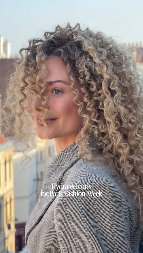 Instagram post by @juliehocke for Moroccanoil. Caption reads: [...] Hydrated curls for PFW 🤍 @moroccanoil....
