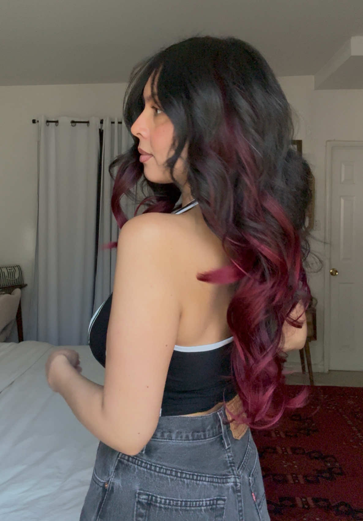 TikTok post by @lynnroxana for Vigorous Beauty. Caption reads: ty niko 🪭 @Vigorous Beauty #burgundyhair #redhair....