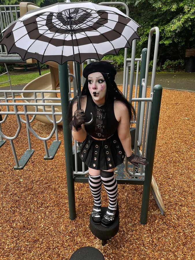 Instagram post by @kryptglow for VampireFreaks. Caption reads: [...] socks: @hottopic Parasol: @vampirefreaks . .....