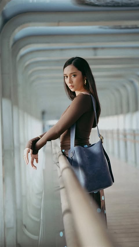 Instagram post by @asha.assuncao for Coach. Caption reads: Walk in, own it, carry Coach💙 #CoachNY....