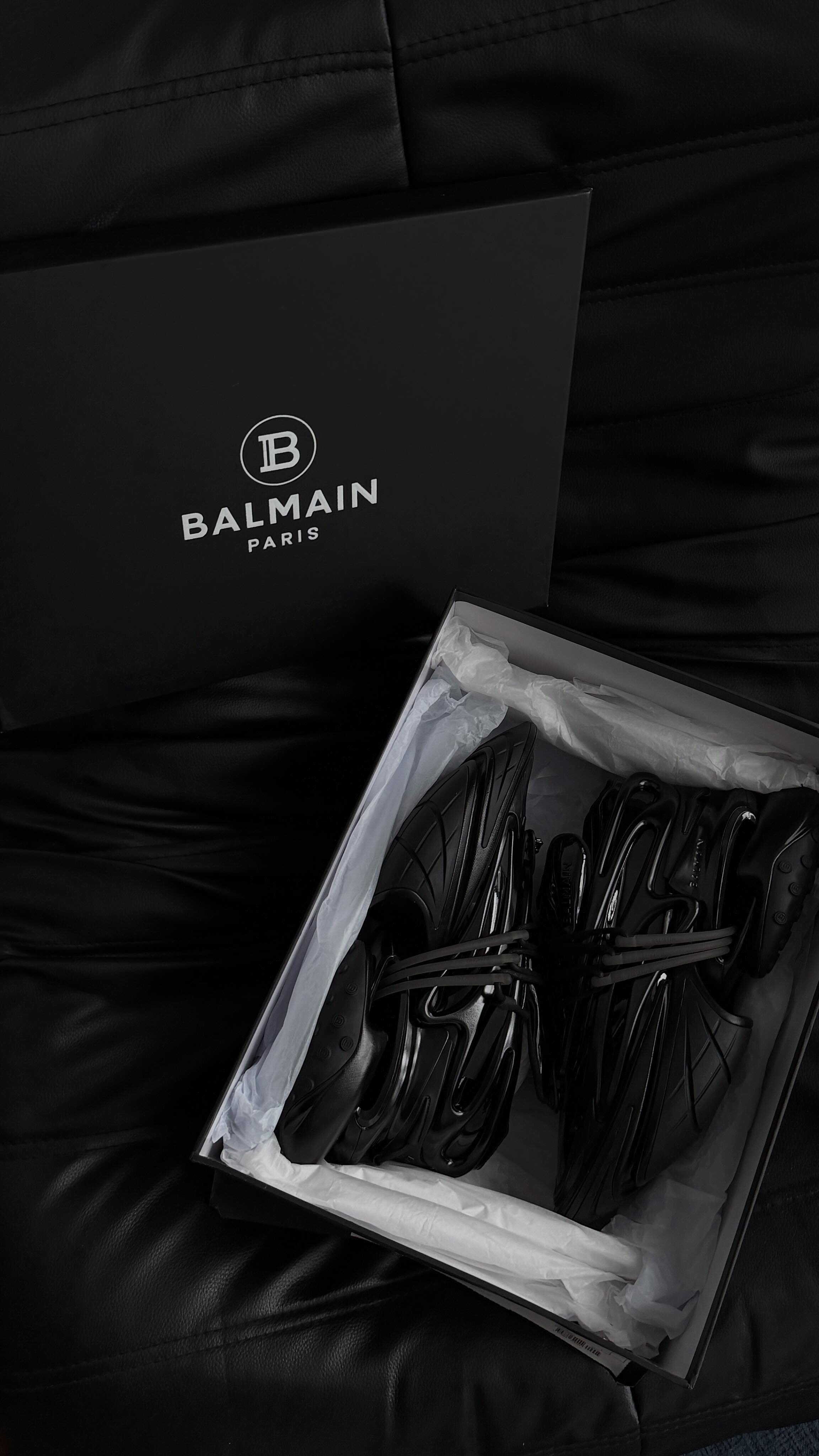 Instagram post by @iyzdham for Balmain. Caption reads: Bought my first pair of @balmain 🖤🥹🫶🏻👟
What....