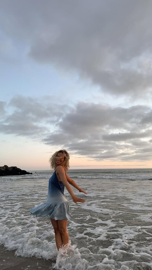 Instagram post by @rebekahlynnkalis for Dear John Denim. Caption reads: if anything, the ocean makes you remember 🌊🤍....