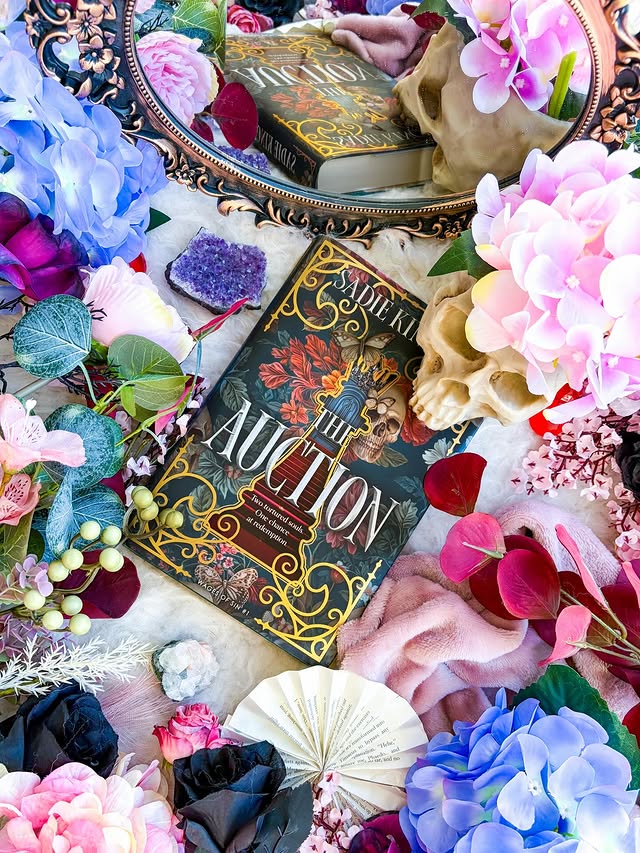 Instagram post by @rachels_crystal_library for HarperCollins. Caption reads: 𝐓𝐡𝐞 𝐀𝐮𝐜𝐭𝐢𝐨𝐧 By @sadie_kincaidxx....