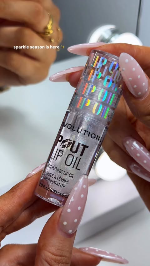 Instagram post by @itsheatherbell for Makeup Revolution. Caption reads: [...] with a sparkly lip oil 🤍✨ from....