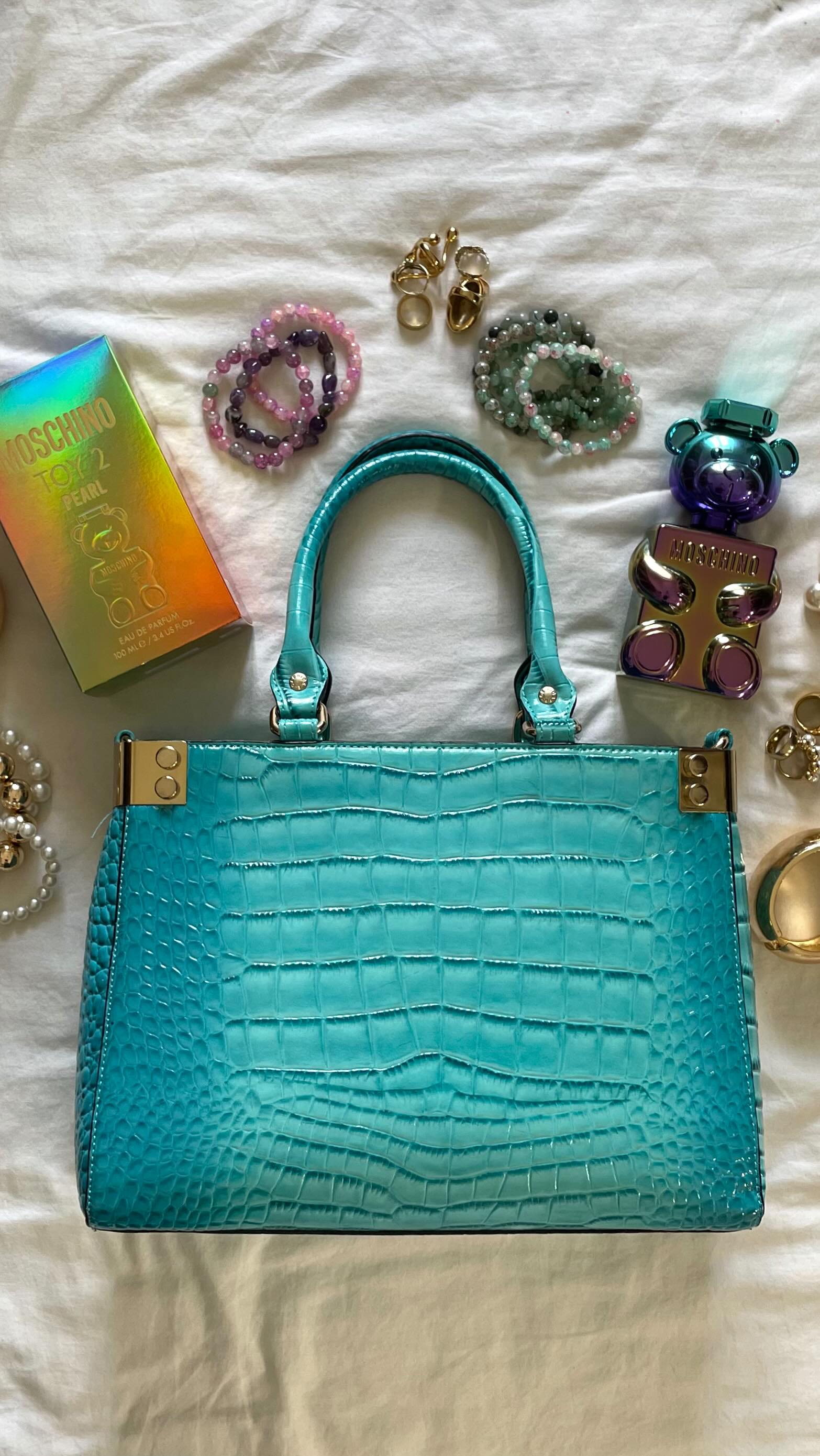 Instagram post by @madamemarleen for Moschino. Caption reads: Anzeige | my bag essentials with @moschino.beauty....