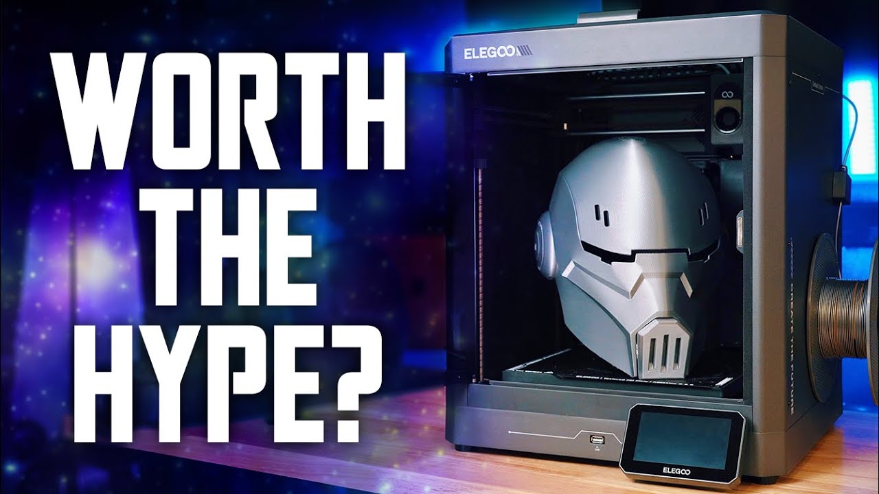 YouTube post by @MMsPropShop for Thingiverse. Caption reads: The Ultimate Budget 3D Printer | Testing the....