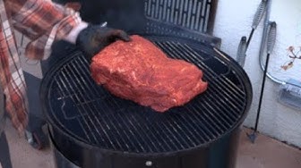 YouTube post by @TROYCOOKS for Heath Riles BBQ. Caption reads: How to Smoke Pork Butt on the Weber Smokey....