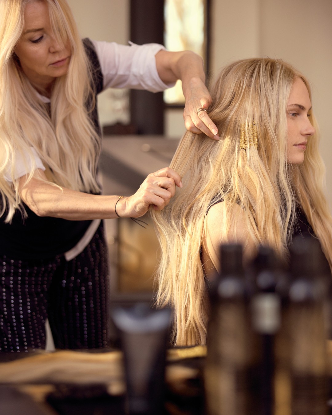 Instagram post by @nicciwelsh for Oribe. Caption reads: The Artistry of Hair 🖤✨ Golden threads, goddess....