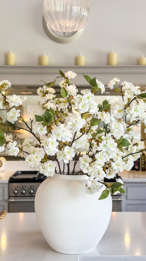 Instagram post by @thehousebuild for The Suffolk Nest. Caption reads: Adding a touch of spring to the kitchen. Real or....