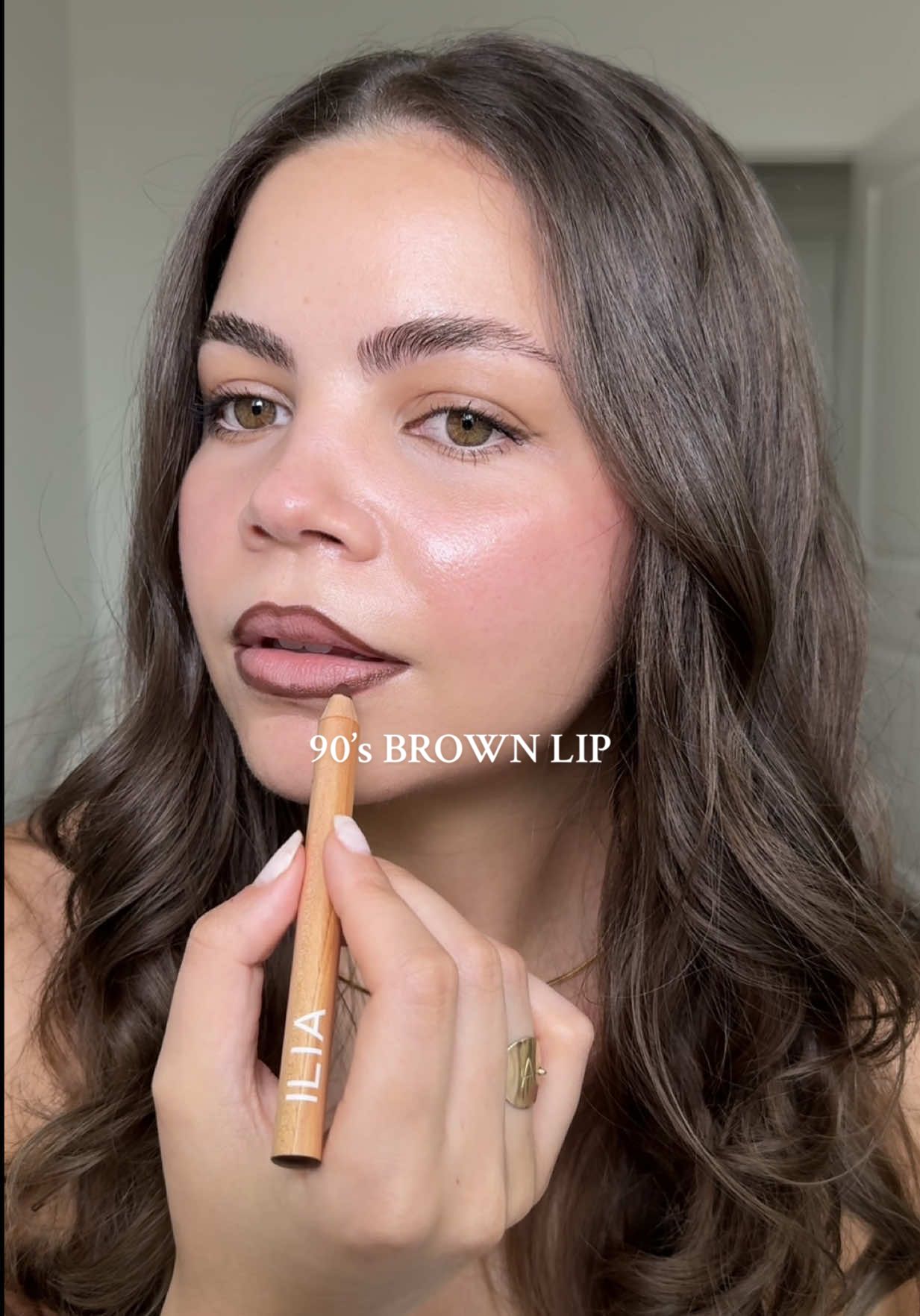 TikTok post by @aislinnfoutz for ILIA Beauty. Caption reads: [...] perfect 90’s brown lip using two of @ILIA....